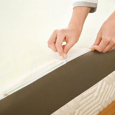 a woman's hand is unzipping her mattress cover